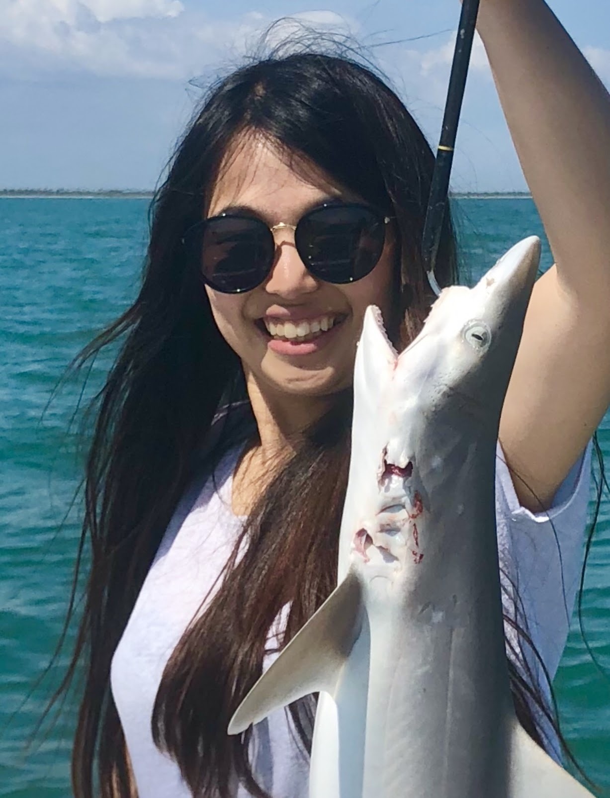 An angler in sunglasses with her catch
