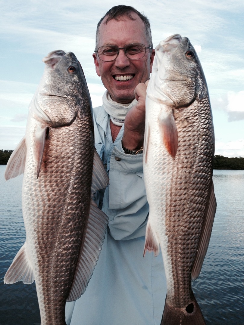 An angler holding two fish