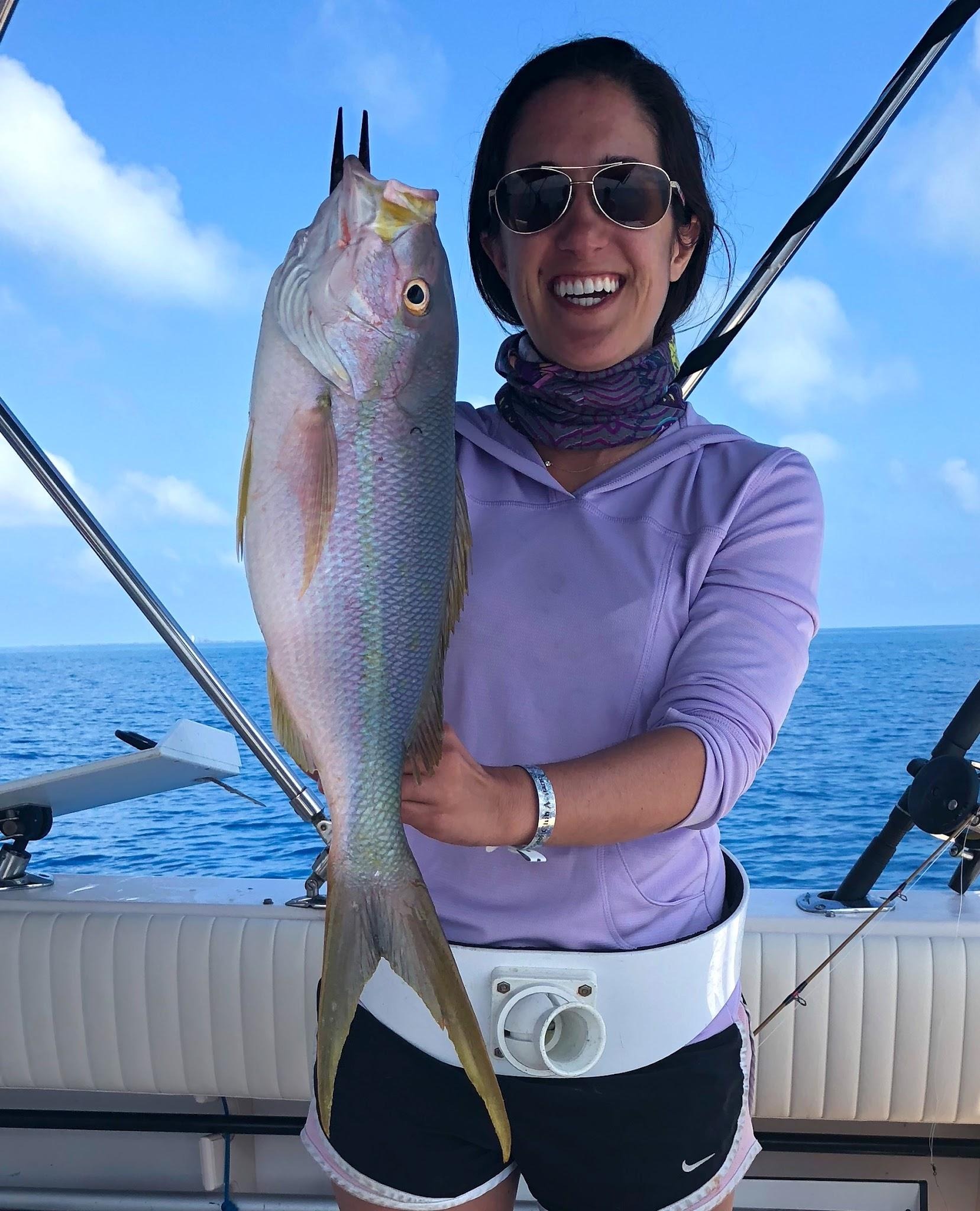 An angler holding her catch aboard Ariel